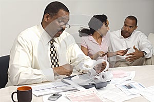 Financial Advisor Holding Expense Receipt With Couple In The Background