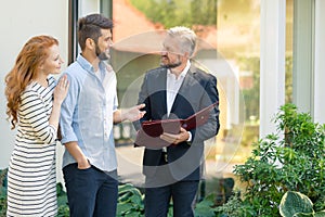 Financial advisor talking about loan with woman and man buying house