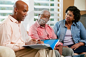 Financial Advisor Talking To Senior Couple At Home