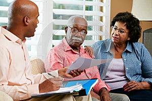 Financial Advisor Talking To Senior Couple At Home