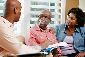 Financial Advisor Talking To Senior Couple At Home