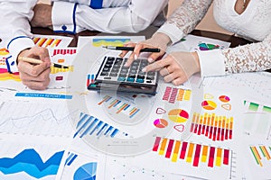 Financial analysts team counting business reports with calculator