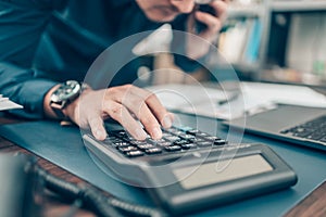 Financial businessman working on desk office using a calculator to calculate calculating corporate income tax data And analyzing