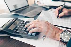 Financial businessman working on desk office using a calculator to calculate calculating corporate income tax data And analyzing