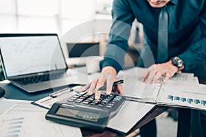 Financial businessman working on desk office using a calculator to calculate calculating corporate income tax data And analyzing