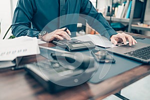 Financial businessman working on desk office using a calculator to calculate calculating corporate income tax data And analyzing