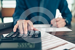 Financial businessman working on desk office using a calculator to calculate calculating corporate income tax data And analyzing