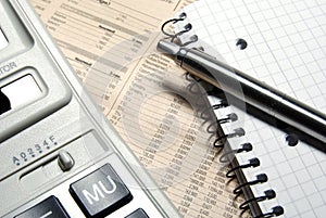 Financial calculator, steel pen and notebook.