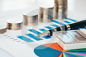 Financial chart with coins, pen and calculator