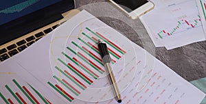 financial chart diagram in white paper with the pen and laptop
