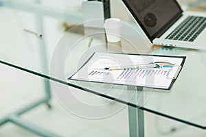 financial chart,pen and notebook at the workplace of the busines