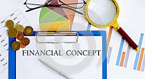 FINANCIAL CONCEPT. Business reports, blank paper , data tables and charts,magnifier,coins - directly above view of office table