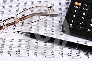 Financial concept. Calculator, pen and glasses on financial documents. Financial accounting. Balance sheets. Closeup of financial