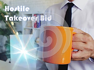 Financial concept about Hostile Takeover Bid Man with a cup of coffee in the background