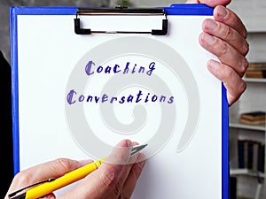 Financial concept meaning Coaching Conversations with sign on the piece of paper