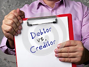 Financial concept meaning Debtor vs. Creditor with inscription on the sheet