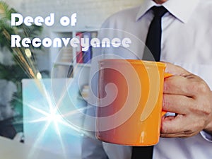 Financial concept meaning Deed of Reconveyance Man with a cup of coffee in the background