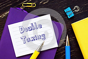 Financial concept meaning Double Taxing with sign on the sheet photo