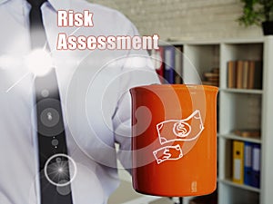 Financial concept meaning Risk Assessment Man with a cup of coffee in the background