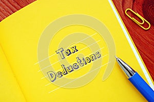 Financial concept meaning Tax Deductions with phrase on the piece of paper
