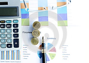 Financial concept with money coins stack and business fountain pen and calculator and eyeglasses and labtop with document chart on