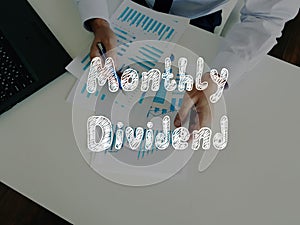 Financial concept about Monthly Dividend with inscription on the page