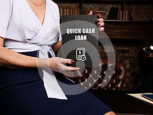 Financial concept about QUICK CASH LOAN with sign on black notepad in hand
