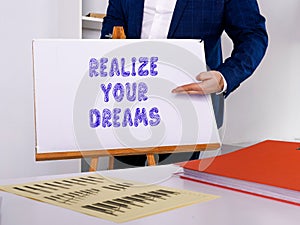 Financial concept about REALIZE YOUR DREAMS with sign on the page