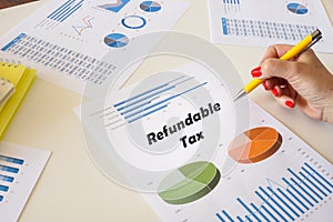 Financial concept about Refundable Tax with inscription on the printout with diagrams and tables