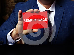 Financial concept about REMORTGAGE with inscription on the page. The process of paying off one mortgage with the proceeds from a photo