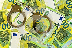 Financial crime concept - handcuffs on cash money