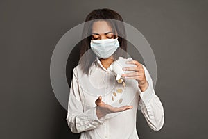 Financial crisis and pandemic concept. Young black woman in medical mack without money photo