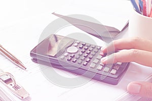 Financial data analyzing. Close-up photo of a businessman's hand counting on calculator in office or home