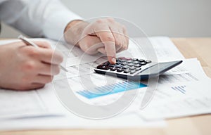 Financial data analyzing. Counting on calculator. photo