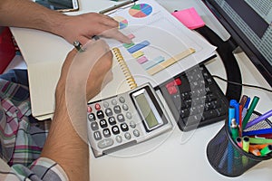 Financial data analyzing. Counting on calculator. Hand on calculator