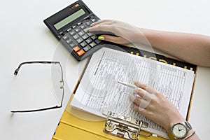 Financial data analyzing. Counting on calculator. Hand with pen