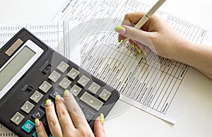 Financial data analyzing. Counting on calculator. Hand with pen on financial table