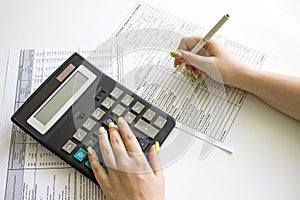 Financial data analyzing. Counting on calculator. Hand with pen on financial table