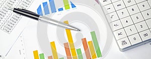 Financial development - calculator and pen on chart and graph paper