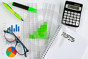 Financial documents, with green cubes arranged in a column graph as a concept for increasing profits