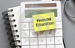 Financial Education Words on a small sheet of paper located on the calculator