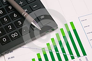 Financial growth chart and calculator with a pen close-up. Stock market analysis. Financial and accounting reporting