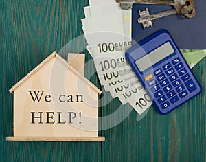 Financial helping concept - little house with text We can help!, keys, calculator, passport, money