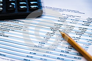 Financial income statement with calculator and pencil
