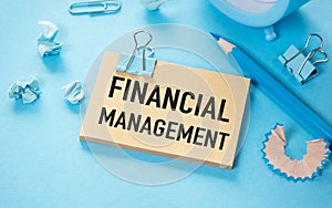 Financial Management open notepad with text on a blue background multi- colored stationery.