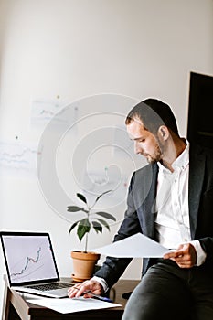 financial manager analyzing price data trend graph on laptop in office