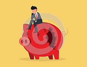 Financial mistake. depressed businessman sitting on a broken piggy bank