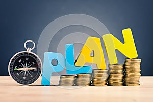 word PLAN and stacking coins on wooden desk over beautiful reverberation gradient background