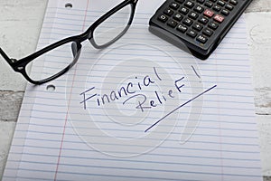 Financial Relief hand written in pen on lined notebook paper