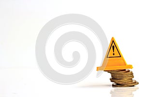 Financial risk. Coins falling and Warning label on whitebackground